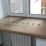 Деревянный стол-подоконник с отверстиями над радиатором отопления